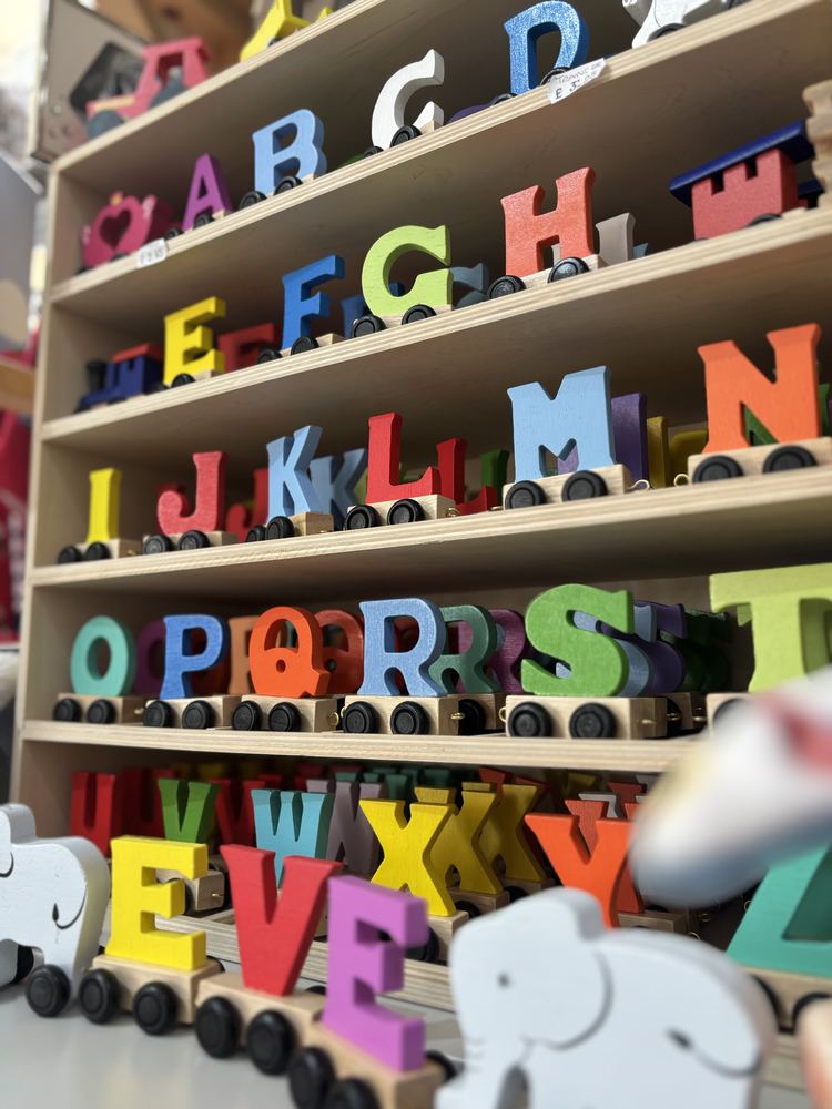 Colourful wooden alphabet train letters on shelves in the shop